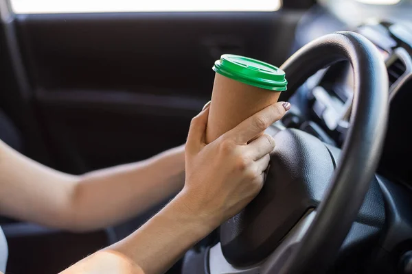Uma mulher sem rosto está bebendo café em um copo de artesanato enquanto dirige. Tome uma bebida tônica quente para levar embora — Fotografia de Stock