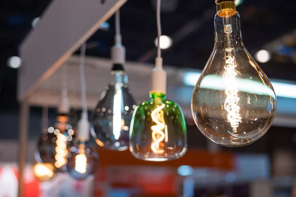 Muitas lâmpadas incandescentes de forma diferente são suspensas no escuro — Fotografia de Stock
