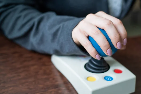 Woman with cerebral palsy works on a specialized computer mouse. — Stock Photo, Image