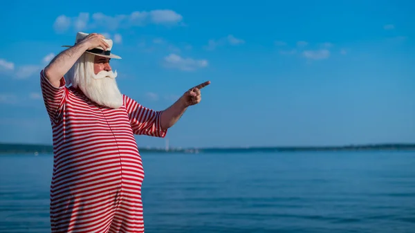 Un uomo anziano in costume da bagno retrò a righe sulla riva del mare — Foto Stock