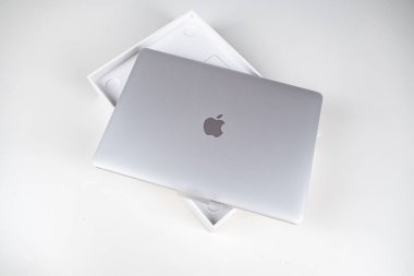 Beyaz bir masada gümüş renkli bir Macbook havası açıyorum. Apple dizüstü