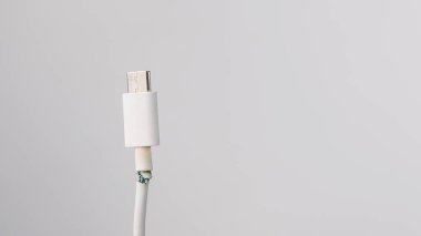 Beyaz arka planda cep telefonu tipi si şarj etmek için kopmuş kablo. Boşluğu kopyala.