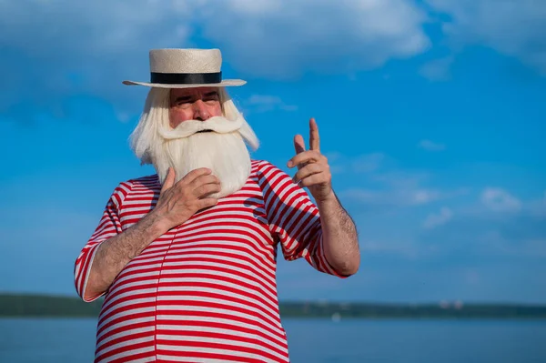 Un uomo anziano in costume da bagno classico passeggia lungo la spiaggia in una calda giornata estiva — Foto Stock