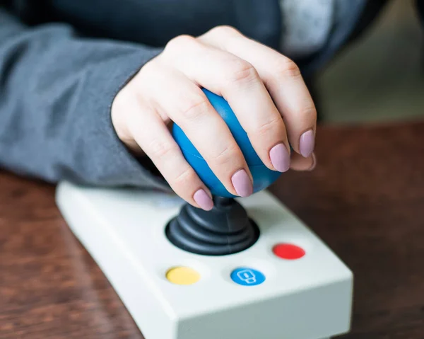 Woman with cerebral palsy works on a specialized computer mouse. — Stock Photo, Image