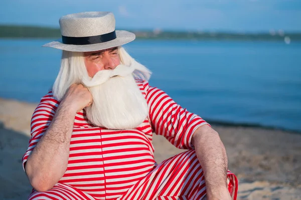 Retrato de un anciano vestido con un traje de baño clásico y un navegante en la playa. — Foto de Stock