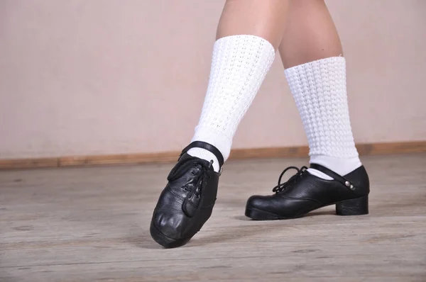 Покриття жіночих ніг в чорних шкіряних туфлях танцює національні ірландські танці. — стокове фото