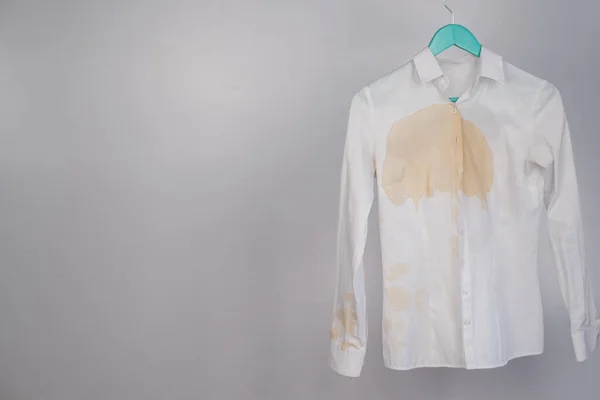 Womens office white shirt with a stain of coffee on a white background. — Stock Photo, Image