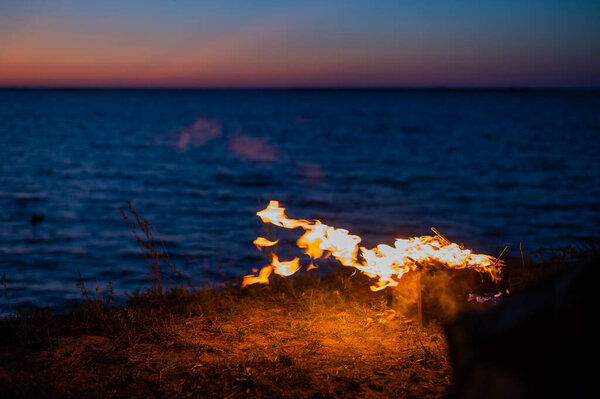 View from a tourist tent on bonfire on the seashore at sunset