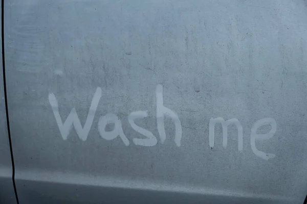 Las letras de dedo me lavan en un coche azul sucio. — Foto de Stock