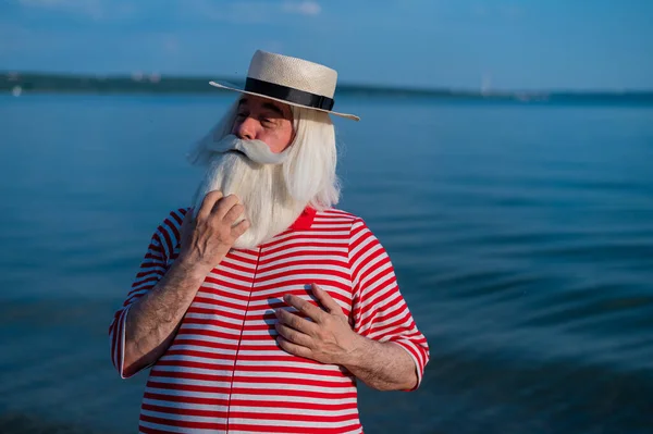 Пожилой человек в классическом купальнике прогуливается по пляжу в жаркий летний день — стоковое фото