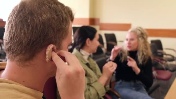 Drie hardhorende en dove studenten communiceren in gebarentaal in een klaslokaal van de universiteit. — Stockvideo