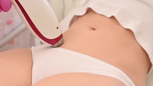 A woman in a beauty salon on a procedure for laser hair removal of unwanted vegetation on the abdomen — Stock Video