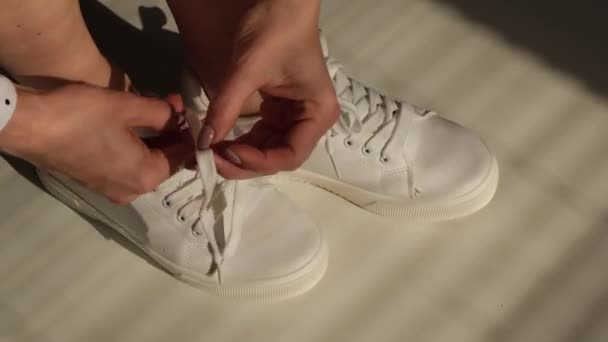 Kvinna sätta på nya vita läder sneakers — Stockvideo