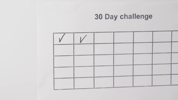 Обрезанный вид женщины, пишущей галочки в коробках 30 дней вызов — стоковое видео