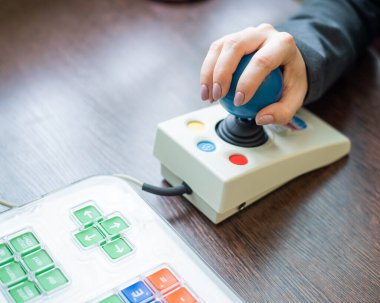 Serebral felçli bir kadın özel bir bilgisayar faresinde çalışıyor..