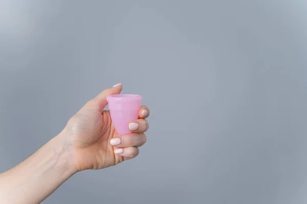 Close-up of a female hand with a pink menstrual cup on a white background. Mengurus lingkungan. Eco ramah perempuan produk kebersihan. Salin ruang — Stok Foto