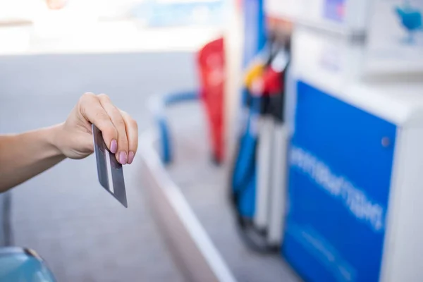 Egy nő hitelkártyával fizet, miközben tankol egy autót. — Stock Fotó