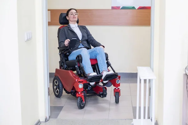 Белая женщина в электрическом кресле в больничном коридоре. — стоковое фото