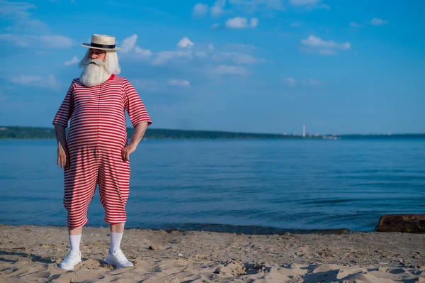 Un uomo anziano in costume da bagno retrò a righe e Boater in riva al mare — Foto Stock