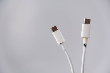 Yırtık ve el değmemiş C tipi cep telefonu şarj kablosunun yakın plan görüntüsü.