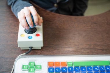 Serebral felçli bir kadın özel bir bilgisayar faresinde çalışıyor..