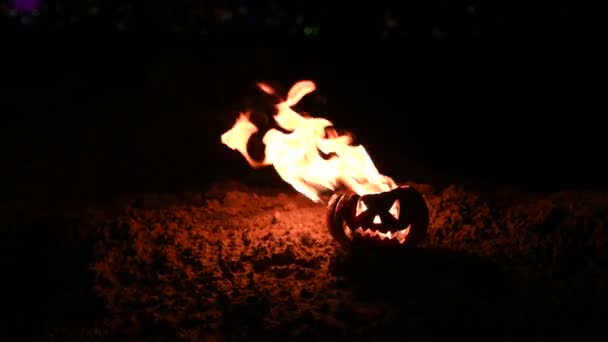 Scary Halloween pumpkin is spewing fire flame on black Background. Jack lantern burns from the inside with an open lid on the ground. — Stock Video