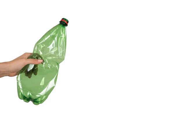 Close-up van een vrouwelijke hand met een groene plastic fles op een witte achtergrond. geïsoleerd — Stockfoto