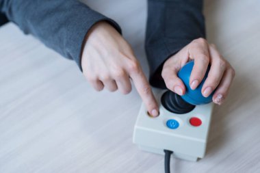 Serebral felçli bir kadın özel bir bilgisayar faresinde çalışıyor..