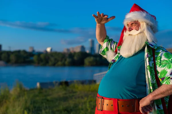 Санта-Клаус в гавайской рубашке ходит по природе. Рождество в тропиках — стоковое фото