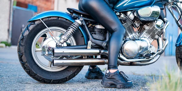 가죽 가죽옷을 입은 한 여성 이 오토바이 위에 앉아 있습니다. 여자 다리가 자전거를 타고 있는 모습 — 스톡 사진