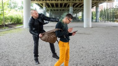 Haydut adamın kafasındaki şişeyi kırmış ve sırt çantasını çalmış. Hırsızlık amacıyla saldırı.