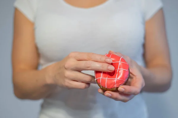 Faceless woman holding a donut imitating sexual intercourse. A metaphor for masturbation — Stock Photo, Image