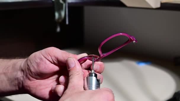Technik optyk poleruje ramę okularów. Profesjonalny optyk naprawia okulary. — Wideo stockowe