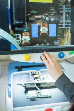 Kadın, görme engellileri okumak için özel bir aletle mikro devreleri inceliyor..