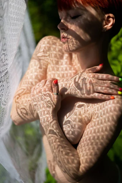 Sexy nude woman in shadow from openwork fabric outdoors in summer. — Stock Photo, Image