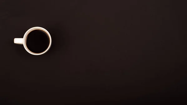 Vista dall'alto di tazza in ceramica bianca con caffè nero su sfondo nero. Copia spazio — Foto Stock