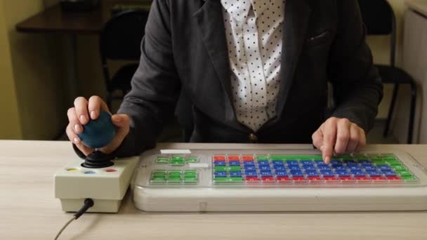 Seorang wanita yang tidak dikenal dengan cerebral palsy adalah mengetik di keyboard. Seorang gadis cacat bekerja pada komputer khusus — Stok Video