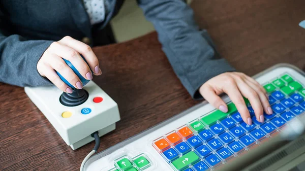 Mujer con parálisis cerebral trabaja en una computadora especializada. — Foto de Stock