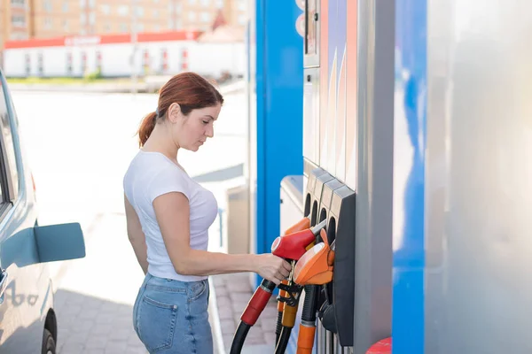 Biała kobieta tankuje samochód na stacji benzynowej samoobsługowej. — Zdjęcie stockowe