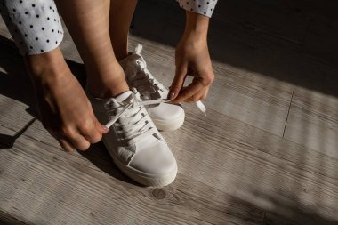 Kadın yeni beyaz deri ayakkabılar giydi.