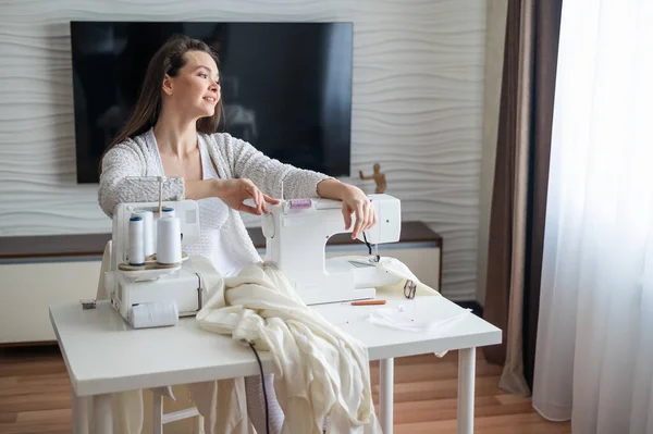 Молода біла жінка шиє вдома — стокове фото