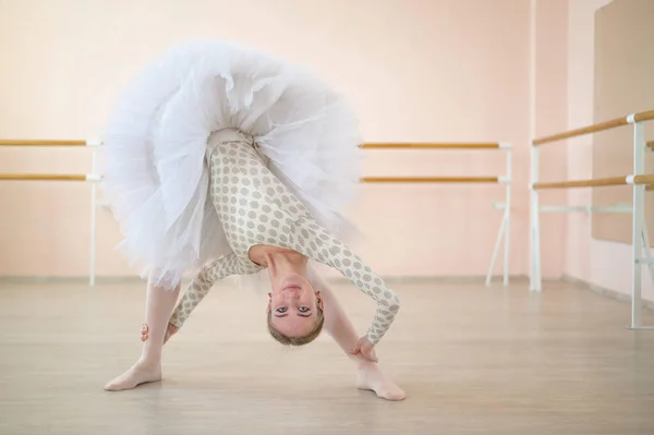 A gyönyörű fiatal balerina szóló szerepet gyakorol egy barréval teli osztályban. A karcsú, kecses táncos az előadás előtt lép fel.. — Stock Fotó
