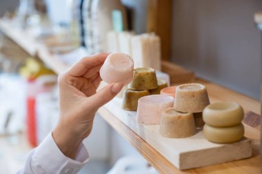 Kadın çevre dostu dükkanda organik sabun seçiyor..