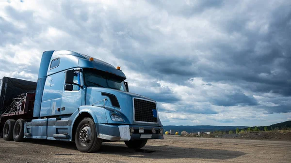 Un camión estacionado con un taxi azul contra un cielo gris —  Fotos de Stock