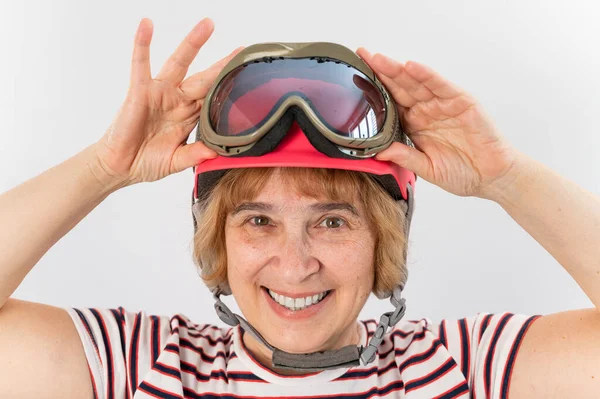 一位老年妇女戴着粉红的滑雪头盔，背景是白色的 — 图库照片