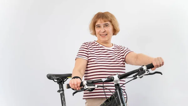 Äldre kvinna på cykel på en vit bakgrund. — Stockfoto