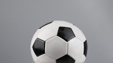 Futbol topu beyaz arka planda dönüyor.