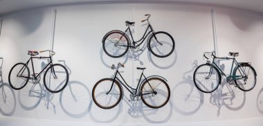 Eski bisikletler dekorasyon olarak beyaz bir duvara asılır.
