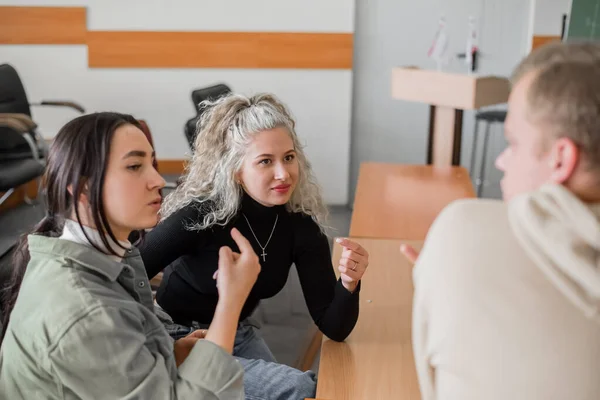 두 소녀와 한 남자가 수화로 말하고 있습니다. 청각 장애가 있는 세 명 의학생 이대학 교실에서 이야기를 나누고 있다. — 스톡 사진