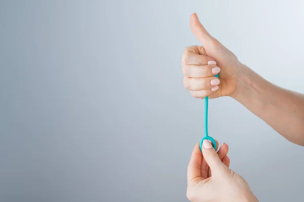 Una mujer sin rostro demuestra una bola vaginal de color menta. Chica sosteniendo un entrenador de Kegel para el entrenamiento de los músculos del suelo pélvico sobre un fondo blanco. — Foto de Stock